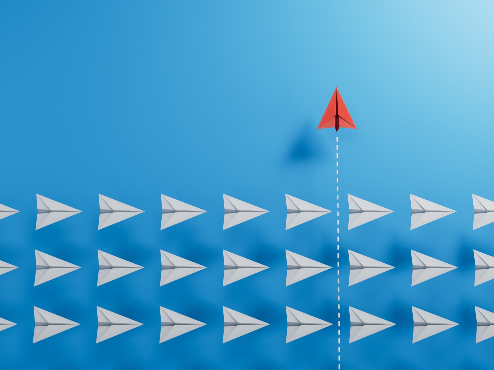 Group of white paper plane in one direction and one red paper plane pointing in different way. Business concept for new ideas, creativity, innovation and solution.3D rendering on blue background.